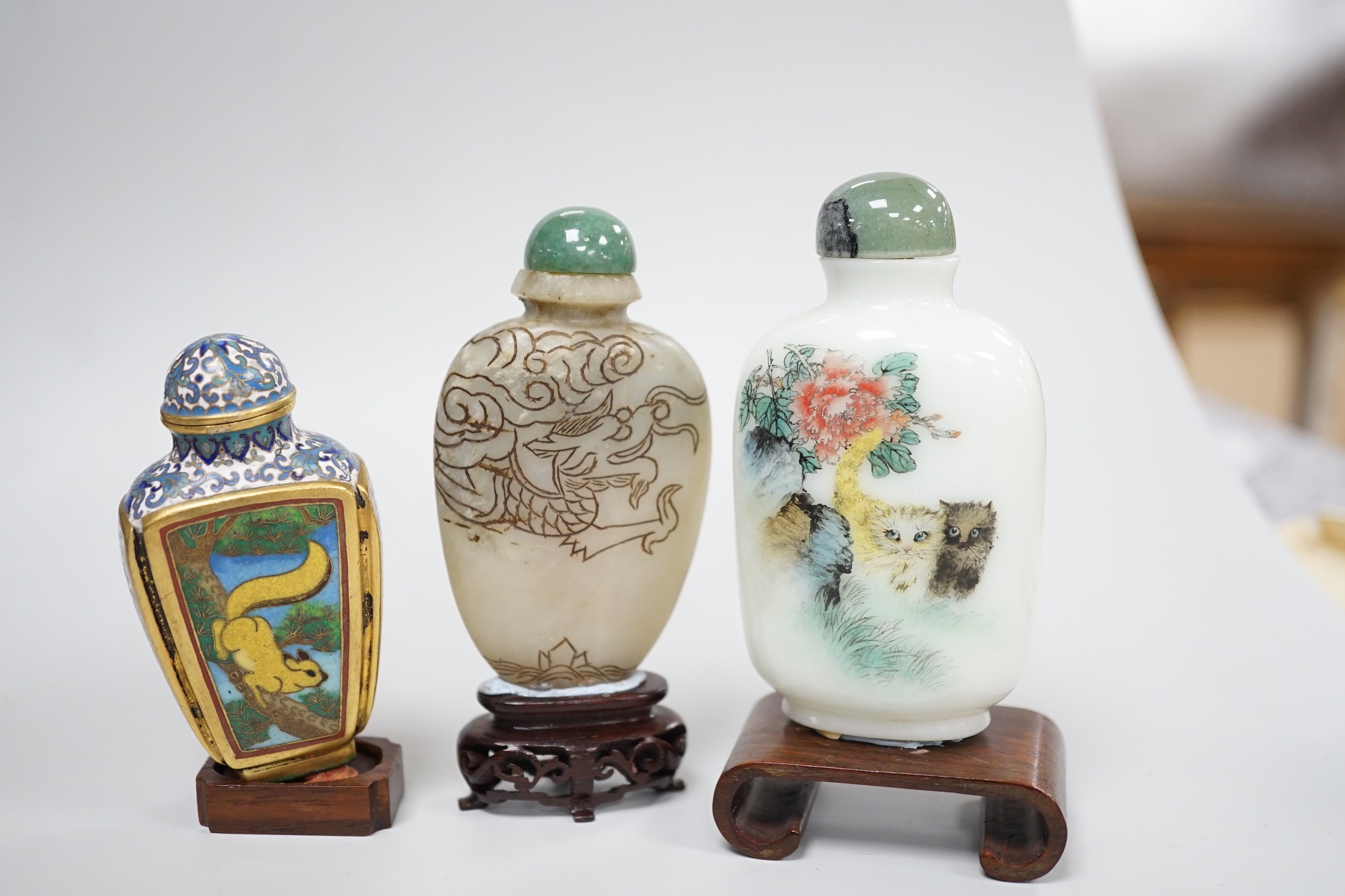 A Chinese cloisonné enamel snuff bottle, enamelled glass and stone snuff bottles. Tallest 8cm (3)